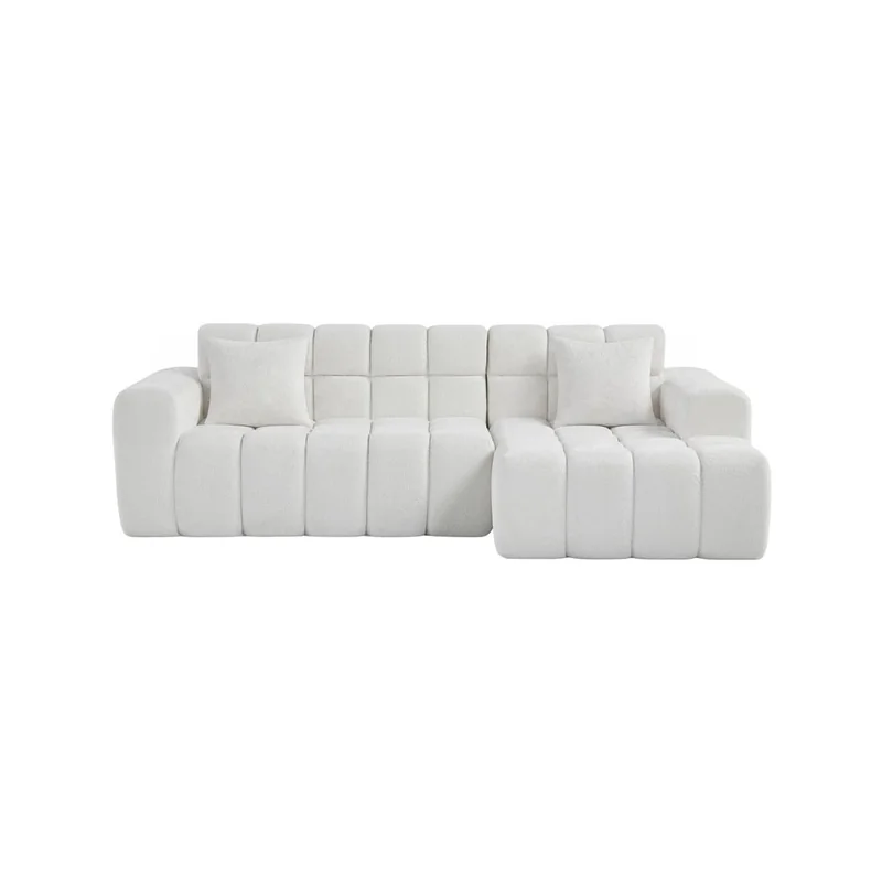 White tufted corner sofa, three seats, chaise longue on the right, with two white scatter cushions, front view on a white background