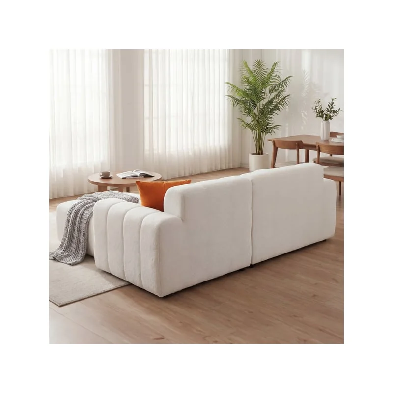 The back of the white corner sofa, upholstered all round