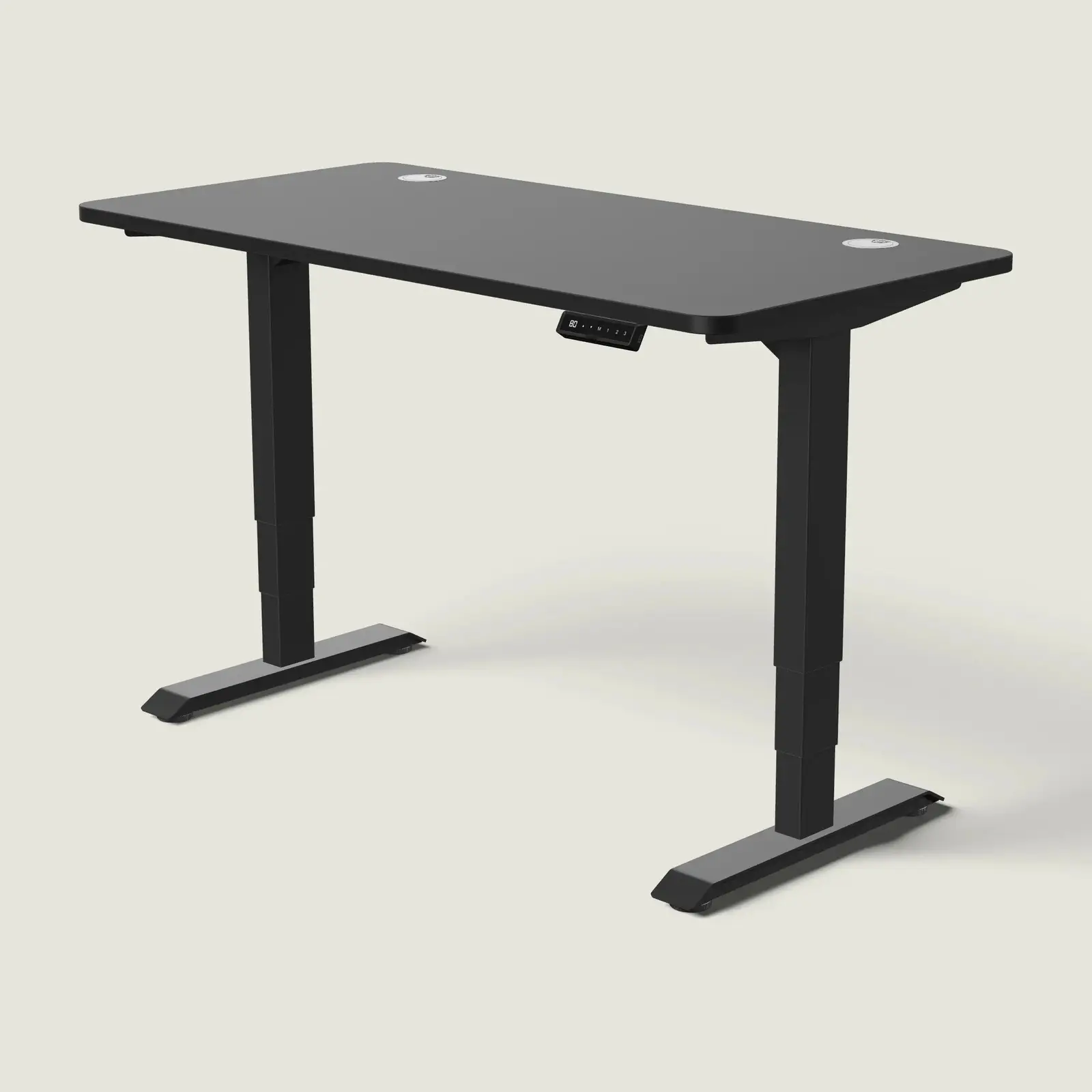 Electric standing desk, 140 × 70 cm, black frame and black top, with the memory handset under the front edge, on a pale grey background