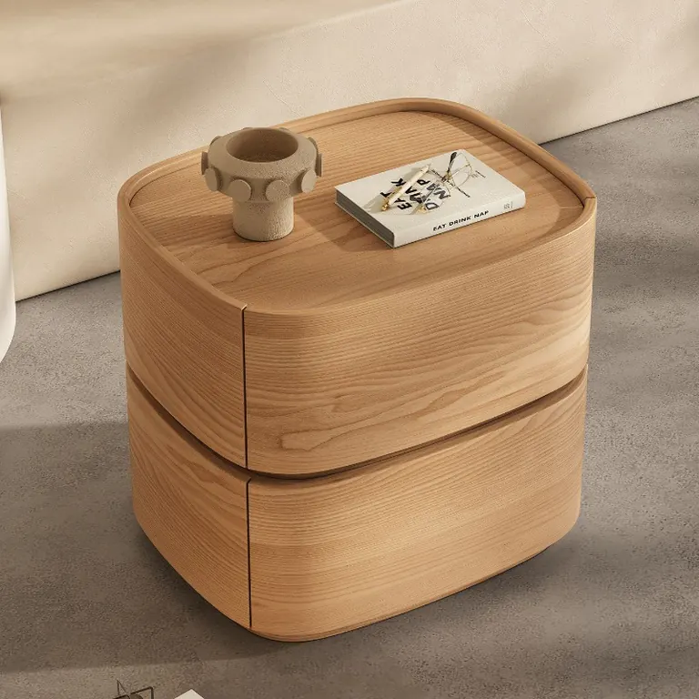 Curved two-drawer bedside table in a natural wood finish, seen from above at an angle